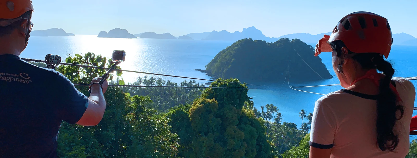 Sunny in her ziplining helmet overlooking the ocean, islands and zip lines in El Nido